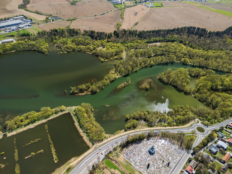 Aerial view of Oravska priehrada reservoir with green water lush trees and a cemetery near a road in Namestovo Zilinsky kraj Slovakia. Aerial view of Oravska priehrada reservoir with green water lush trees and a cemetery near a road in Namestovo Zilinsky kraj Slovakia.