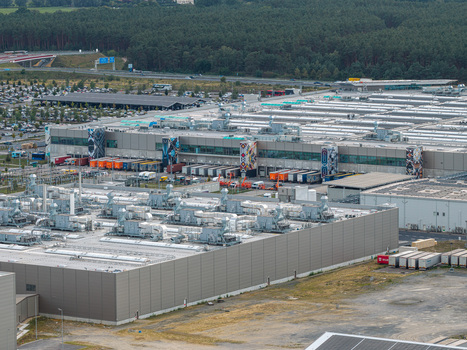 Aerial view of the Tesla Gigafactory Berlin Brandenburg showing the industrial facility loading docks with trucks and surrounding forest Grunheide Mark Brandenburg Germany. Aerial view of the Tesla Gigafactory Berlin Brandenburg showing the industrial facility loading docks with trucks and surrounding forest Grunheide Mark Brandenburg Germany.
