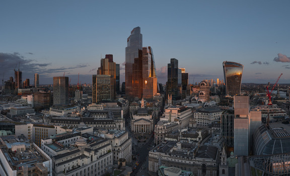 Aerial view of the City of London financial district with modern skyscrapers reflecting golden sunset light and historic architecture below London London United Kingdom. Aerial view of the City of London financial district with modern skyscrapers reflecting golden sunset light and historic architecture below London London United Kingdom.