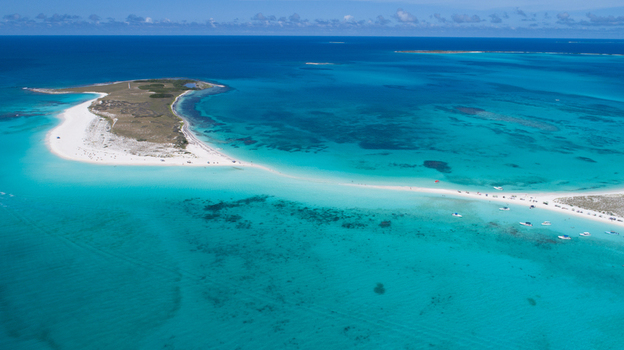 Aerial view of the white sand beaches and turquoise waters of the Los Roques archipelago with small boats anchored in the shallow sea in Los Roques Dependencias Federale Venezuela. Aerial view of the white sand beaches and turquoise waters of the Los Roques archipelago with small boats anchored in the shallow sea in Los Roques Dependencias Federale Venezuela.