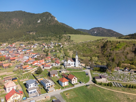 Aerial view of the village of Valaska Dubova featuring the local church and traditional houses surrounded by forested mountains in Valaska Dubova Zilina Region Slovakia. Aerial view of the village of Valaska Dubova featuring the local church and traditional houses surrounded by forested mountains in Valaska Dubova Zilina Region Slovakia.