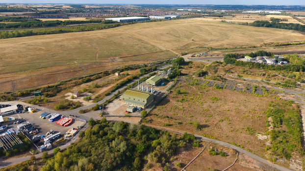 Aerial view of Infinis Power Station surrounded by industrial facilities open fields and lush vegetation in Stewartby England United Kingdom. Aerial view of Infinis Power Station surrounded by industrial facilities open fields and lush vegetation in Stewartby England United Kingdom.