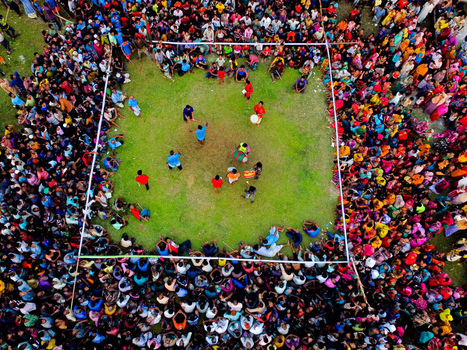 Nilphamari Bangladesh 01 May 2026 Aerial view of a large crowd of people gathered around a square green field for a traditional performance with drummers and participants in the center. Nilphamari Bangladesh 01 May 2026 Aerial view of a large crowd of people gathered around a square green field for a traditional performance with drummers and participants in the center.