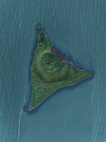 Aerial view of a verdant triangular island rises from the serene blue waters of Lake Mývatn Þingeyjarsveit Iceland. Aerial view of a verdant triangular island rises from the serene blue waters of Lake Mývatn Þingeyjarsveit Iceland.
