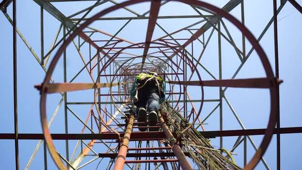 View of a technician climbing a telecommunications tower Bangladesh. View of a technician climbing a telecommunications tower Bangladesh.