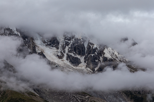 View of the majestic Baltoro Glacier surrounded by snow capped mountain peaks and thick clouds in the rugged landscape of Baltoro Gilgit Baltistan Pakistan.
