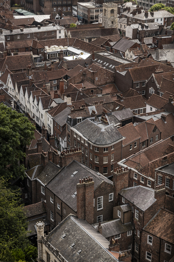 Aerial view of the historic city of York featuring dense clusters of traditional brick rooftops narrow streets and stone chimneys in York England United Kingdom.
