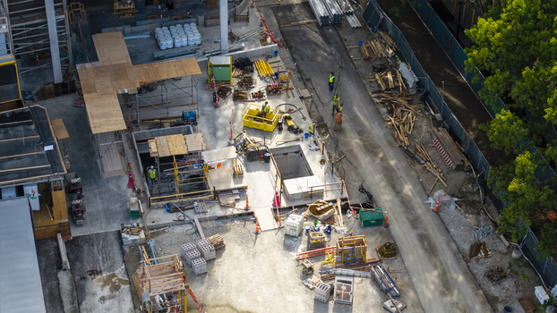 Aerial view of the Kendall Square construction site featuring workers scaffolding building materials and heavy equipment in Cambridge Massachusetts United States. Aerial view of the Kendall Square construction site featuring workers scaffolding building materials and heavy equipment in Cambridge Massachusetts United States.