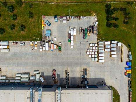 Aerial view of a logistics warehouse yard with organized rows of stacked materials shipping containers and industrial equipment on a concrete surface in Zebrak Central Bohemian Region Czechia. Aerial view of a logistics warehouse yard with organized rows of stacked materials shipping containers and industrial equipment on a concrete surface in Zebrak Central Bohemian Region Czechia.