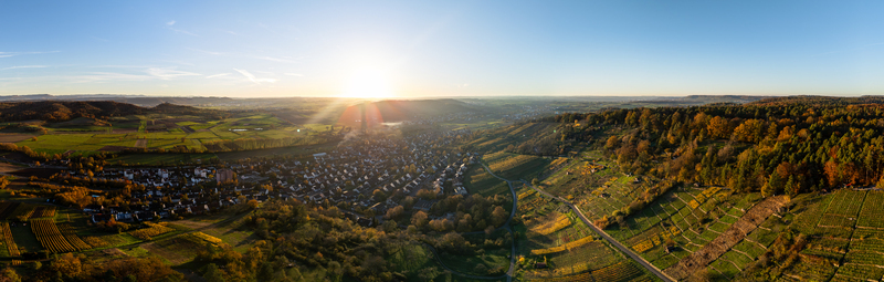 Aerial view of Unterjesingen village surrounded by terraced vineyards and rolling hills under a bright setting sun Tubingen Baden Wurttemberg Germany. Aerial view of Unterjesingen village surrounded by terraced vineyards and rolling hills under a bright setting sun Tubingen Baden Wurttemberg Germany.