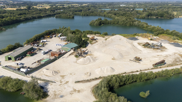 Aerial view of Extraccion de aridos Lima S.L industrial site with sand piles machinery and buildings surrounded by water and vegetation in Vilarino das Poldras Ourense Spain. Aerial view of Extraccion de aridos Lima S.L industrial site with sand piles machinery and buildings surrounded by water and vegetation in Vilarino das Poldras Ourense Spain.