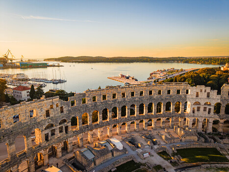 Aerial view of the Pula Arena basks in the golden light of dawn overlooking the Adriatic Sea a testament to ancient Roman architecture Pula Istria County Croatia.