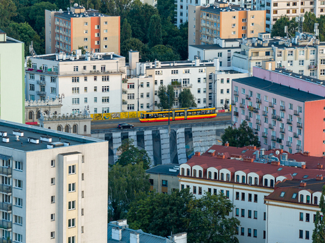 Warsaw Poland 29 July 2025 Aerial view of a yellow and red tram crossing a bridge surrounded by residential apartment buildings and lush green trees in the city. Warsaw Poland 29 July 2025 Aerial view of a yellow and red tram crossing a bridge surrounded by residential apartment buildings and lush green trees in the city.