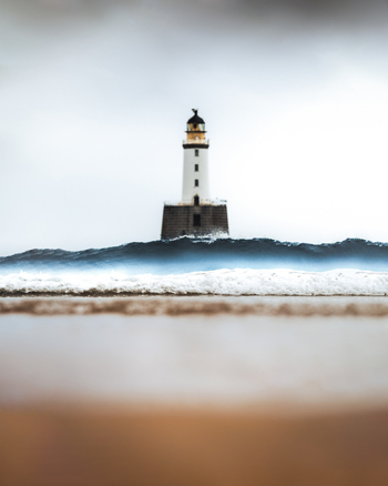 View of a beautiful lighthouse on the coastline with waves crashing on the beach Crimond Great Britain.