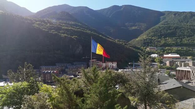 Aerial view of Andorra la Vella with national flag Andorra.