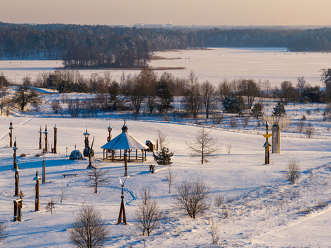 Aerial view of the Hill of Angels featuring wooden sculptures and a gazebo in a snow covered winter landscape with a frozen lake in Traku rajonas Vilniaus apskritis Lithuania. Aerial view of the Hill of Angels featuring wooden sculptures and a gazebo in a snow covered winter landscape with a frozen lake in Traku rajonas Vilniaus apskritis Lithuania.