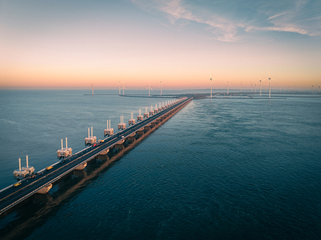 Aerial view of the Delta Projects Netherlands storm surge barrier and wind turbines at sunset over the North Sea in Vrouwenpolder Zeeland Netherlands.