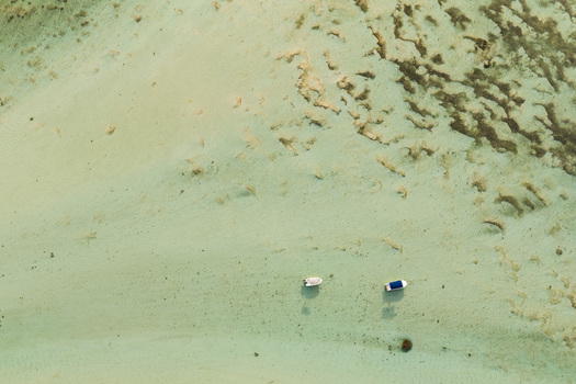 Aerial view of two small boats anchored in shallow turquoise water over a sandy seabed in Moka District Mauritius. Aerial view of two small boats anchored in shallow turquoise water over a sandy seabed in Moka District Mauritius.