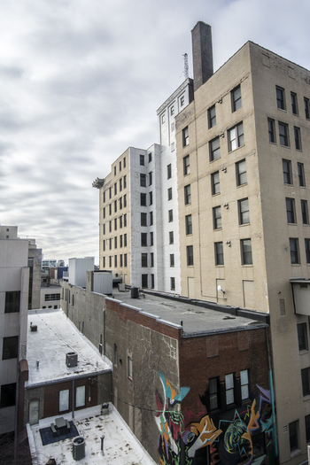 View of urban buildings with colorful graffiti on a brick wall under a cloudy sky in downtown Lincoln Nebraska United States.