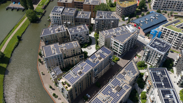 Aerial view of modern apartment buildings with solar panels on rooftops along the canal at Cruquiusweg in Amsterdam Noord Holland Netherlands.