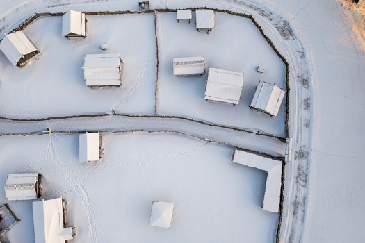 Aerial view of traditional wooden houses and fences covered in thick snow at the Kernave Archaeological Site Kernave Vilnius County Lithuania.