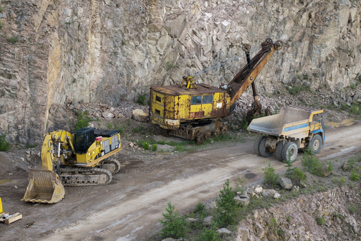 Aerial view of heavy machinery including a yellow excavator and a vintage shovel working in the Porphyry and diabase mine in Krakow Lesser Poland Voivode Poland. Aerial view of heavy machinery including a yellow excavator and a vintage shovel working in the Porphyry and diabase mine in Krakow Lesser Poland Voivode Poland.