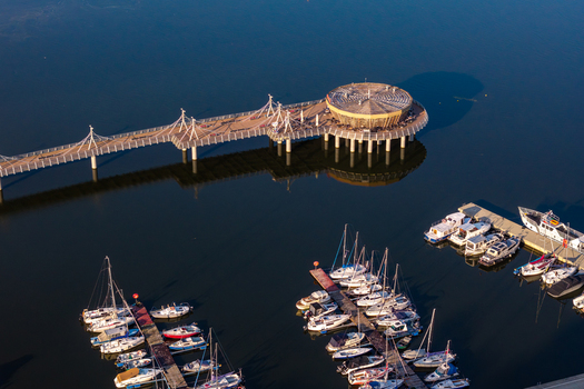 Aerial view of the modern pier and marina with docked sailboats and motorboats on the Vistula River in Plock Masovian Voivodeship Poland. Aerial view of the modern pier and marina with docked sailboats and motorboats on the Vistula River in Plock Masovian Voivodeship Poland.