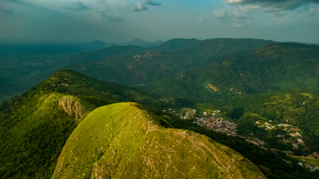 Aerial view of Mt. Gemi rising above the lush green mountains and the village of Amedzofe under a dramatic sky in Amedzofe Volta Region Ghana. Aerial view of Mt. Gemi rising above the lush green mountains and the village of Amedzofe under a dramatic sky in Amedzofe Volta Region Ghana.