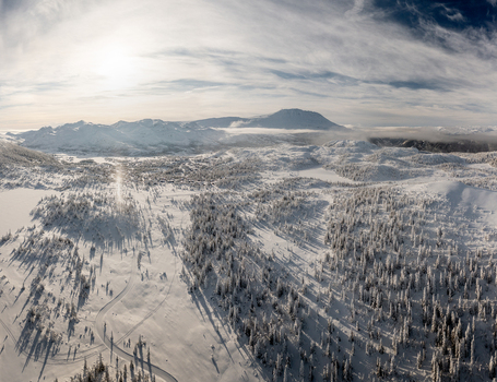 Aerial view of Gaustablikk Fjellresort surrounded by snow covered pine forests frozen lakes and the majestic Gaustatoppen mountain under a bright winter sky Rjukan Telemark Norway. Aerial view of Gaustablikk Fjellresort surrounded by snow covered pine forests frozen lakes and the majestic Gaustatoppen mountain under a bright winter sky Rjukan Telemark Norway.