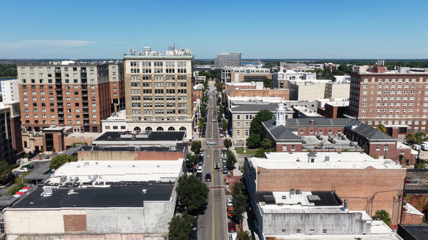 Aerial view of downtown Wilmington featuring historic brick buildings city streets and modern architecture under a clear blue sky in Wilmington North Carolina United States.