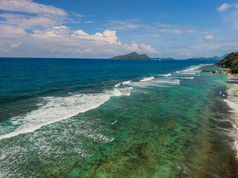 Aerial view of the vibrant turquoise waters meeting the sandy shorelines with distant islands fading into the horizon La Retraite Mahe Island Seychelles. Aerial view of the vibrant turquoise waters meeting the sandy shorelines with distant islands fading into the horizon La Retraite Mahe Island Seychelles.