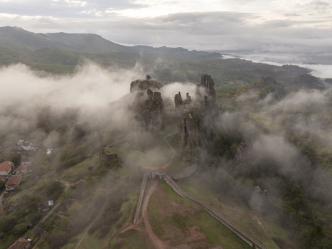 Aerial view of the historic Belogradchik Fortress surrounded by dramatic rock formations and low hanging morning mist in the Balkan Mountains Belogradchik Vidin Bulgaria. Aerial view of the historic Belogradchik Fortress surrounded by dramatic rock formations and low hanging morning mist in the Balkan Mountains Belogradchik Vidin Bulgaria.