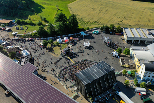 Geiselwind Germany 21 June 2025 Aerial view of the Eventzentrum Strohofer Geiselwind musichall with a large stage crowds of people and tents surrounded by green fields. Geiselwind Germany 21 June 2025 Aerial view of the Eventzentrum Strohofer Geiselwind musichall with a large stage crowds of people and tents surrounded by green fields.