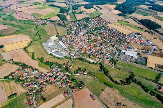 Aerial view of the town of Wachenroth with its red roofed houses surrounded by vast agricultural fields and green meadows in Wachenroth Bavaria Germany. Aerial view of the town of Wachenroth with its red roofed houses surrounded by vast agricultural fields and green meadows in Wachenroth Bavaria Germany.
