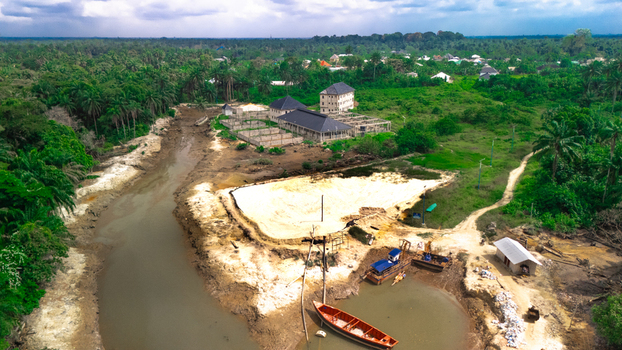 Aerial view of Bukuma settlement in Buguma featuring a river tropical vegetation construction sites and small wooden boats moored in the water Buguma Rivers Nigeria.