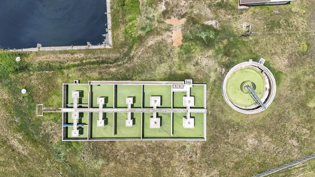 Aerial view of a water treatment facility featuring rectangular and circular tanks with green water situated near the Vaal River in Villiers Free State South Africa. Aerial view of a water treatment facility featuring rectangular and circular tanks with green water situated near the Vaal River in Villiers Free State South Africa.