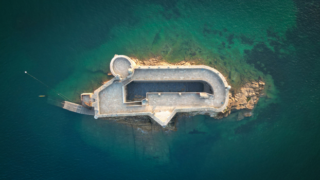 Aerial view of the Ch&acirc;teau du Taureau stands defiant against the turquoise sea its stone walls aged by the salty spray of the Bretagne coast Plouezoc h Bretagne France.