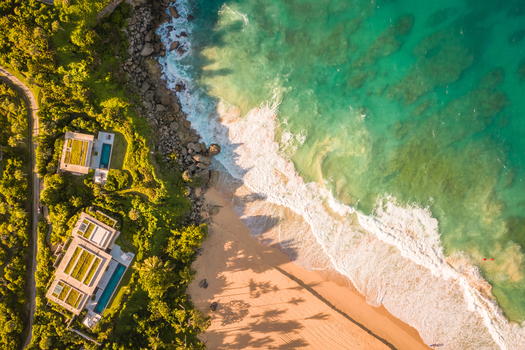 Aerial view of a luxury resort facing the Ocean with waves crashing on the beach on a paradise island Mar&iacute;a Trinidad S&aacute;nchez Dominican Republic.