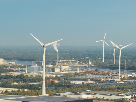 Genk Flanders Belgium 27 August 2026 Aerial view of wind turbines situated in an industrial landscape near a canal and bridge.