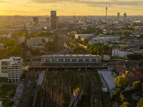 Aerial view of the Ostkreuz railway station with complex intersecting tracks modern urban architecture and the Berlin TV Tower in the distance during golden hour in Berlin Berlin Germany. Aerial view of the Ostkreuz railway station with complex intersecting tracks modern urban architecture and the Berlin TV Tower in the distance during golden hour in Berlin Berlin Germany.