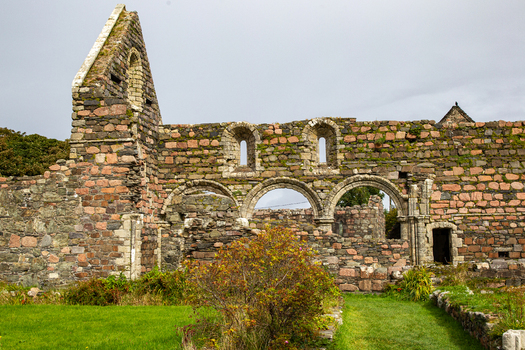 View of the ancient stone ruins and Romanesque arches of Iona Nunnery under an overcast sky in Baile Mor Scotland United Kingdom. View of the ancient stone ruins and Romanesque arches of Iona Nunnery under an overcast sky in Baile Mor Scotland United Kingdom.