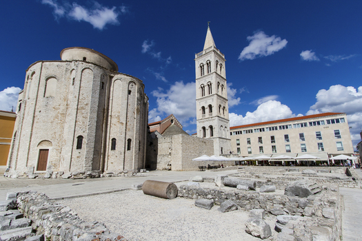 View of the Roman Forum s weathered stones contrast against the ancient cylindrical structure and the towering St. Donatus church a timeless scene Zadar Zadar County Croatia.