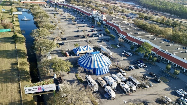Aerial view of blue and white striped circus tents contrasting against the vast parking lot and red roofed outlets near the World Golf Village St. Augustine Florida United States. Aerial view of blue and white striped circus tents contrasting against the vast parking lot and red roofed outlets near the World Golf Village St. Augustine Florida United States.