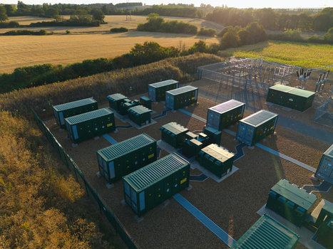 Aerial view of the BESS Grendon battery energy storage facility with green containerized units and electrical infrastructure in a fenced compound in Northampton England United Kingdom. Aerial view of the BESS Grendon battery energy storage facility with green containerized units and electrical infrastructure in a fenced compound in Northampton England United Kingdom.