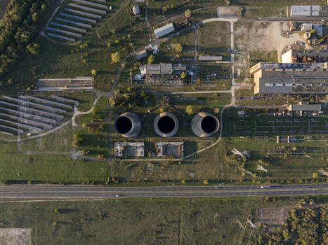 Aerial view of the abandoned Inota Power Plant cooling towers surrounded by industrial ruins grassy fields and solar panels in Varpalota Hungary. Aerial view of the abandoned Inota Power Plant cooling towers surrounded by industrial ruins grassy fields and solar panels in Varpalota Hungary.