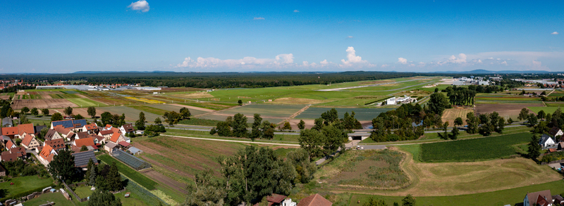 Aerial view of Nuremberg Airport with its runway surrounded by green agricultural fields and village houses under a blue sky in Nuremberg Bavaria Germany. Aerial view of Nuremberg Airport with its runway surrounded by green agricultural fields and village houses under a blue sky in Nuremberg Bavaria Germany.