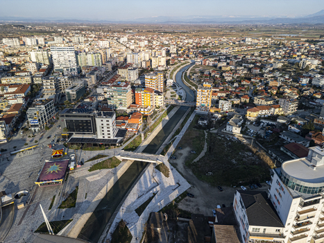 Aerial view of Fier Plaza and the Gjanica River flowing through the urban landscape with modern buildings and bridges in Fier Fier County Albania. Aerial view of Fier Plaza and the Gjanica River flowing through the urban landscape with modern buildings and bridges in Fier Fier County Albania.