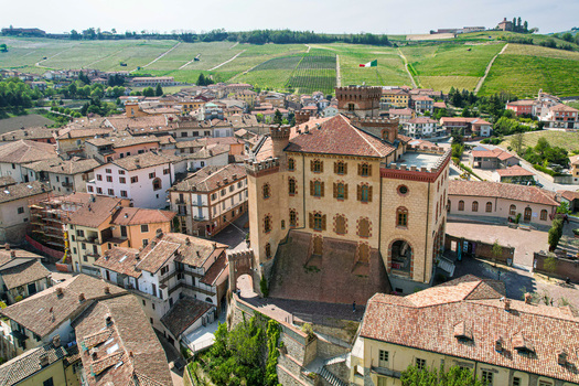 Aerial view of Castello Falletti di Barolo surrounded by historic rooftops and rolling vineyards in Barolo Piedmont Italy. Aerial view of Castello Falletti di Barolo surrounded by historic rooftops and rolling vineyards in Barolo Piedmont Italy.