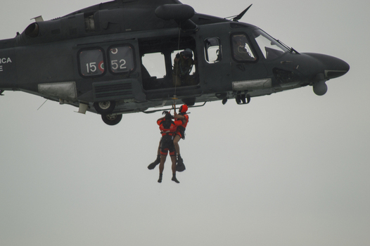Porto San Giorgio Marche Italy 13 September 2015 View of an Aeronautica Militare Italiana helicopter performing a search and rescue hoist operation with a rescuer and person.