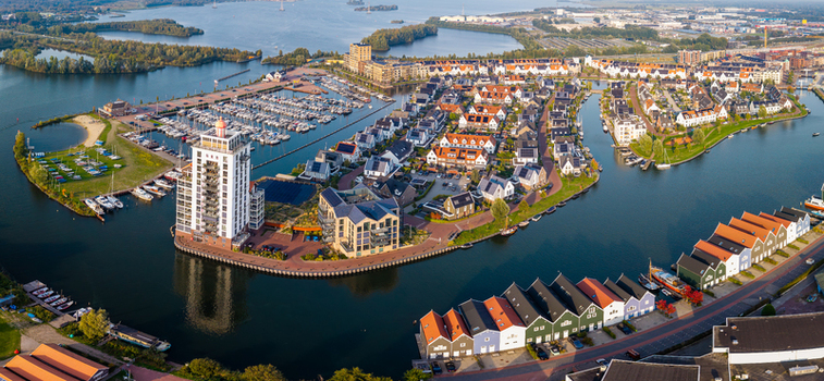 Aerial view of the waterfront district in Harderwijk featuring modern residential buildings a marina with boats and colorful houses along the canal in Harderwijk Gelderland Netherlands.